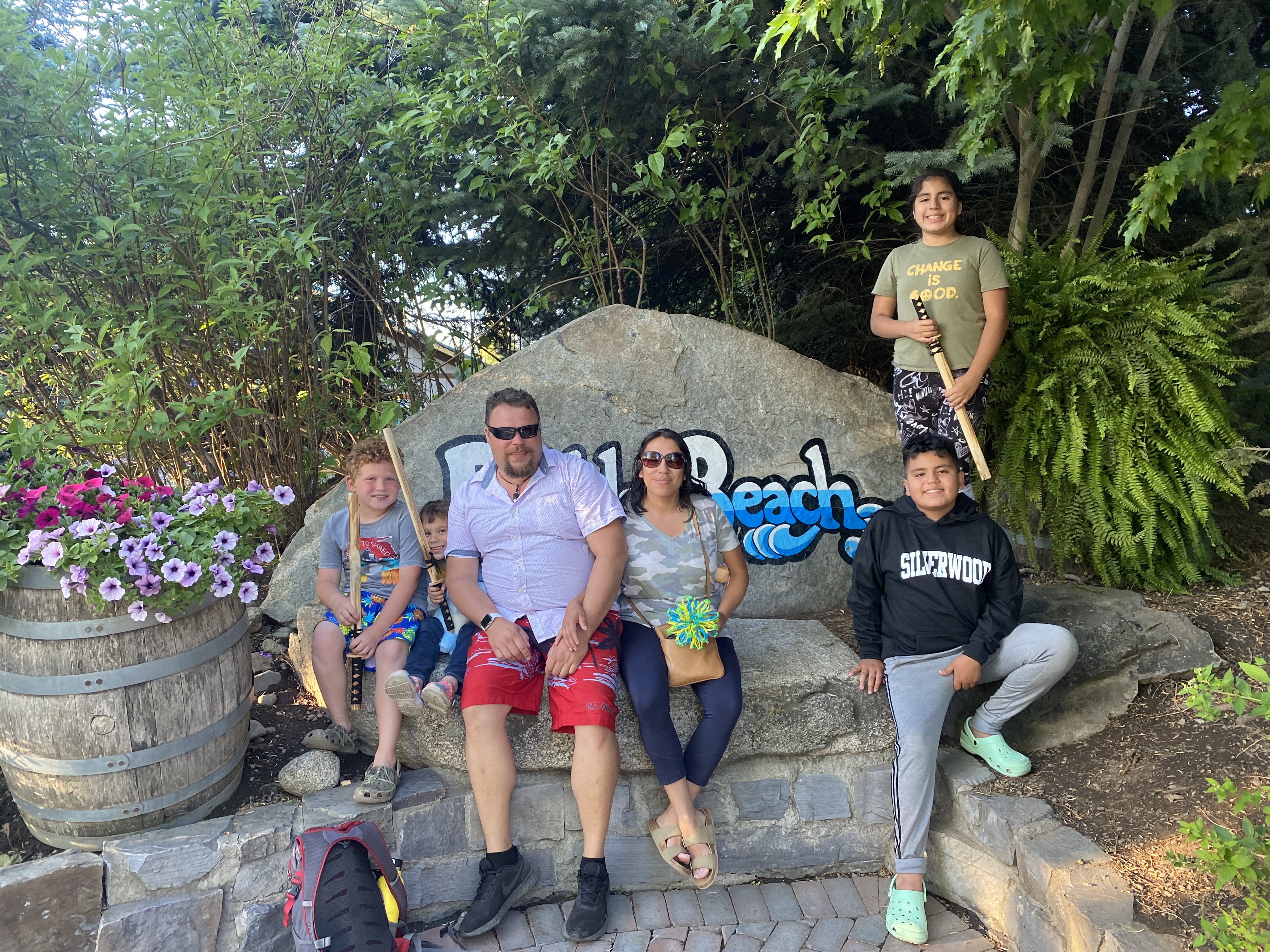 Photo of my family sitting in front of the boulder beach sign