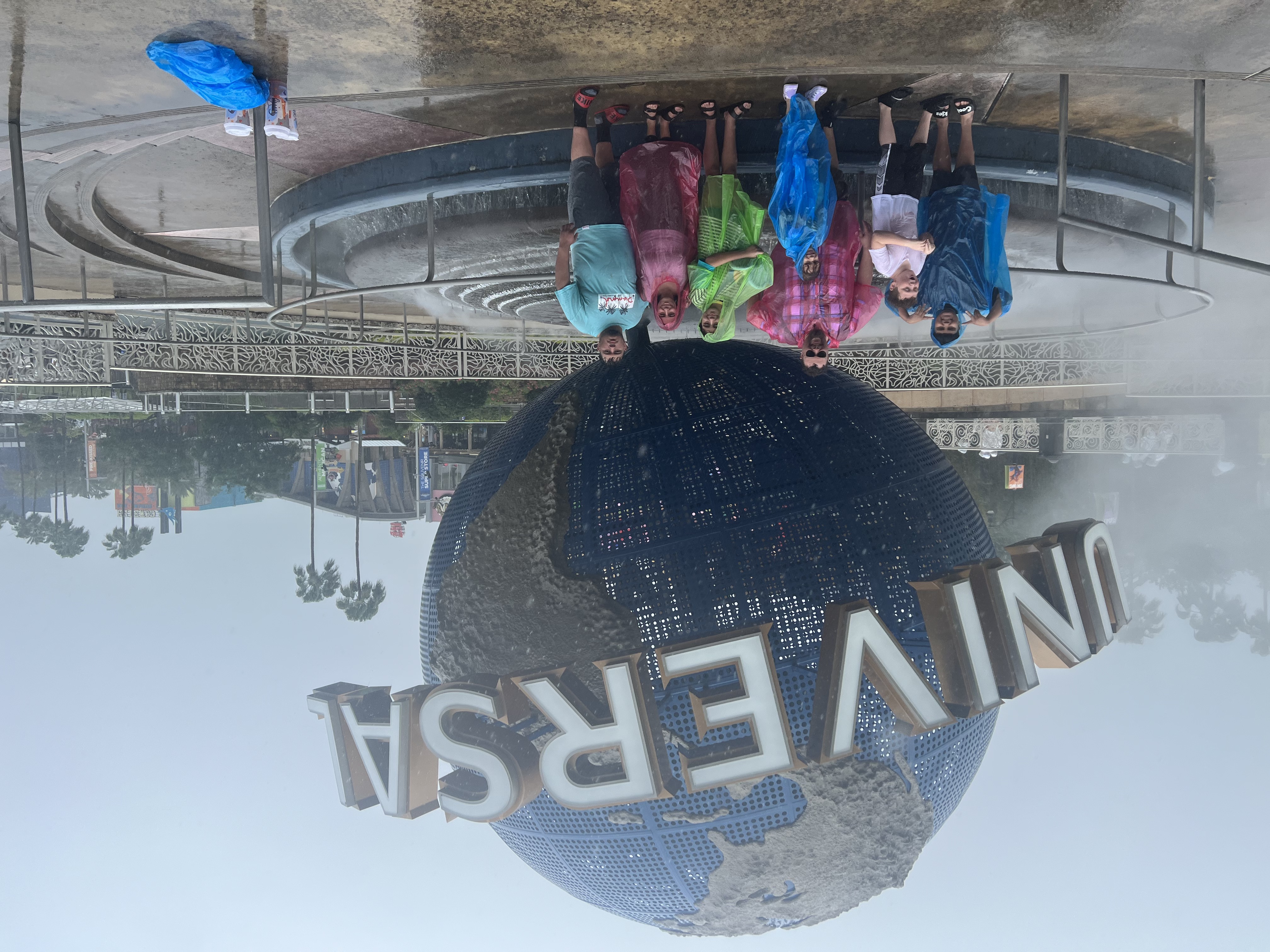 Photo of Campbell/Rodriguez family with pouring rain in front of the Universal Studio's Globe