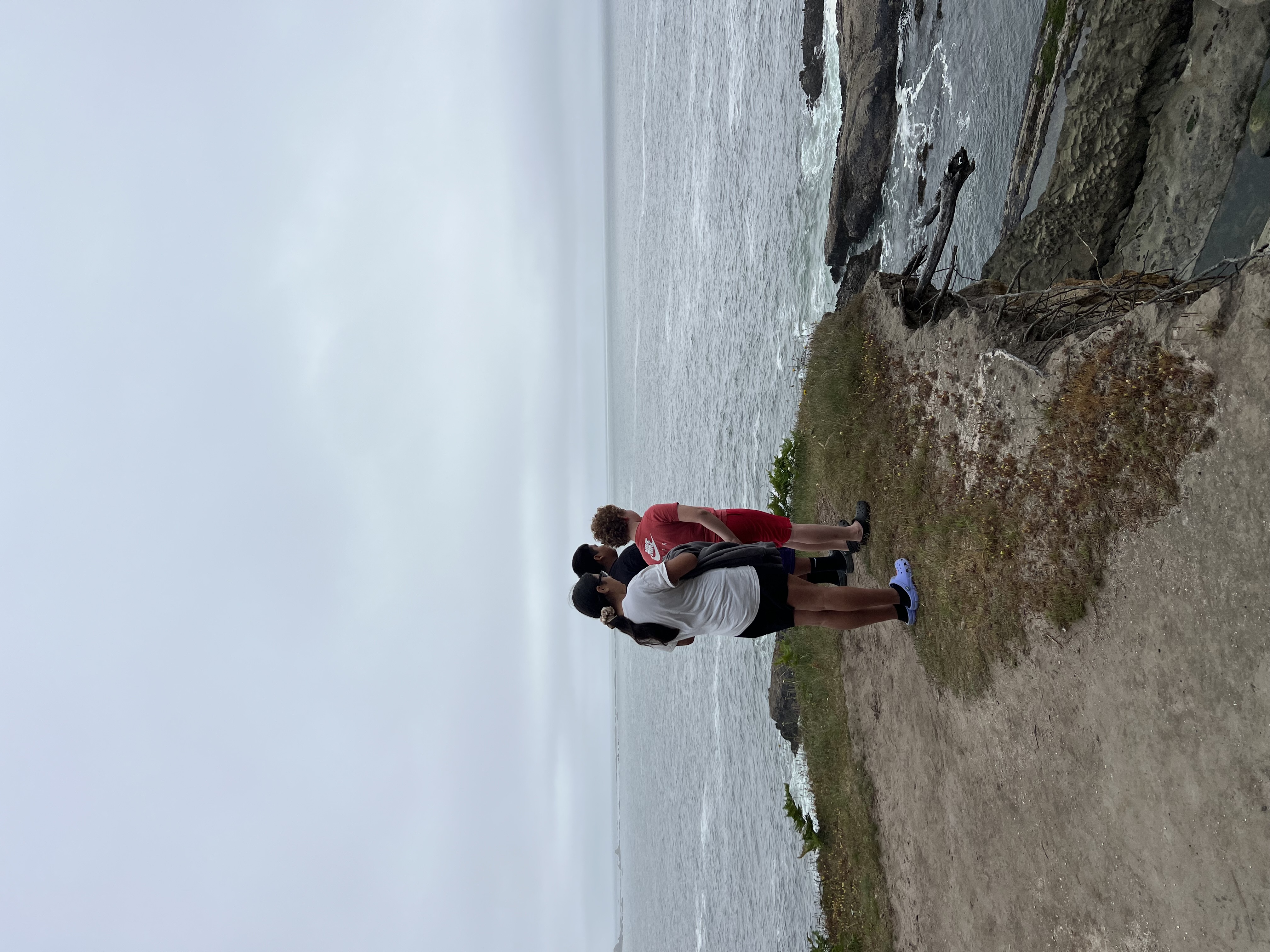 Three kids looking over a cliff