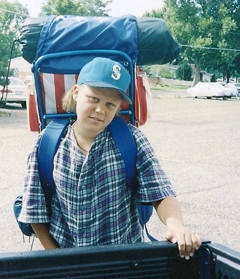 A scanned photo of Jacob Campbell during his middle school years, with an American Flag backpack