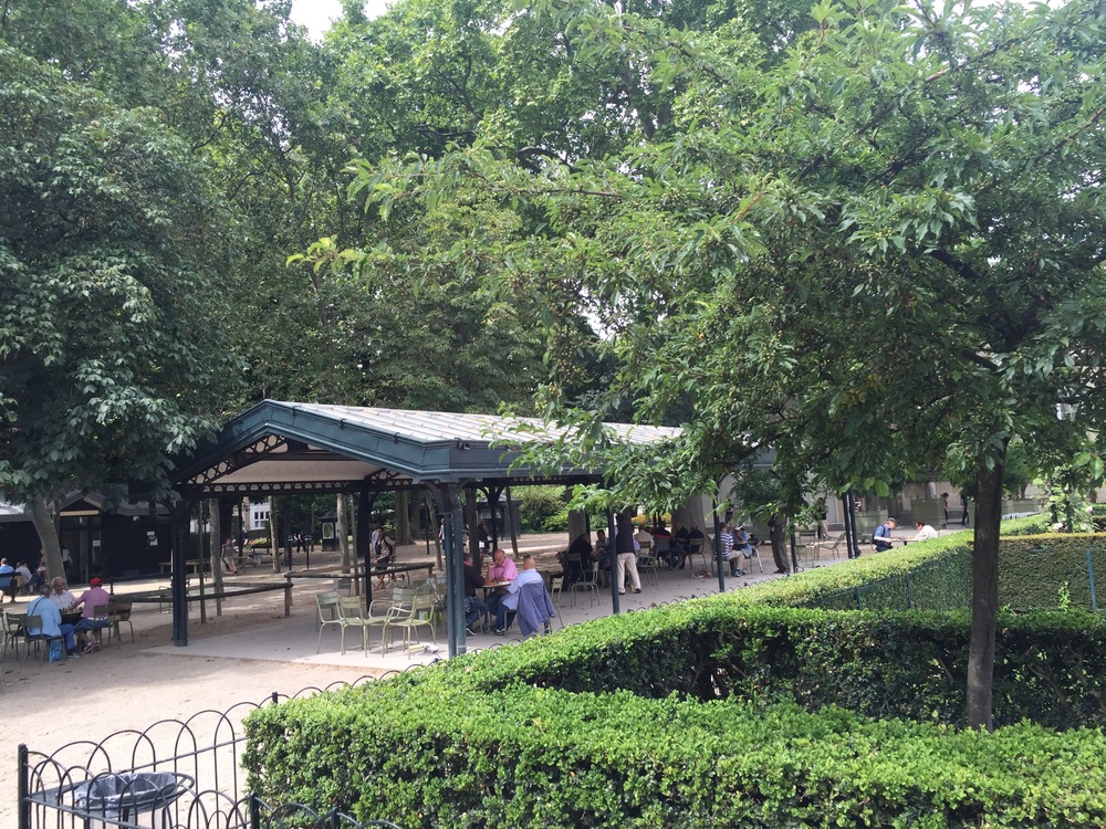 A photo of people playing chess at the Jardin du Luxembourg.